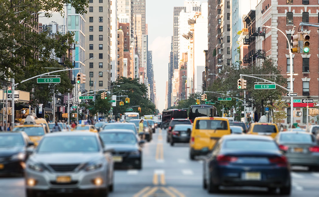 New York City busy street scene with cars and people along 3rd Avenue in the East Village of Manhattan